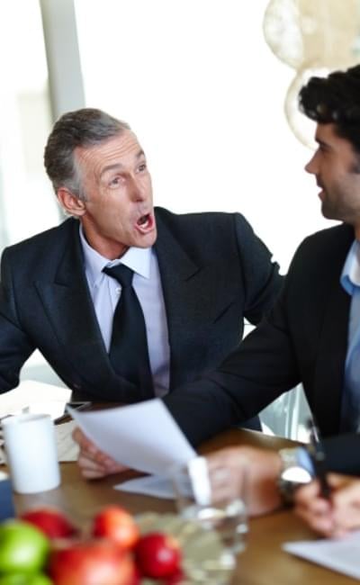 Man looking at his upset boss